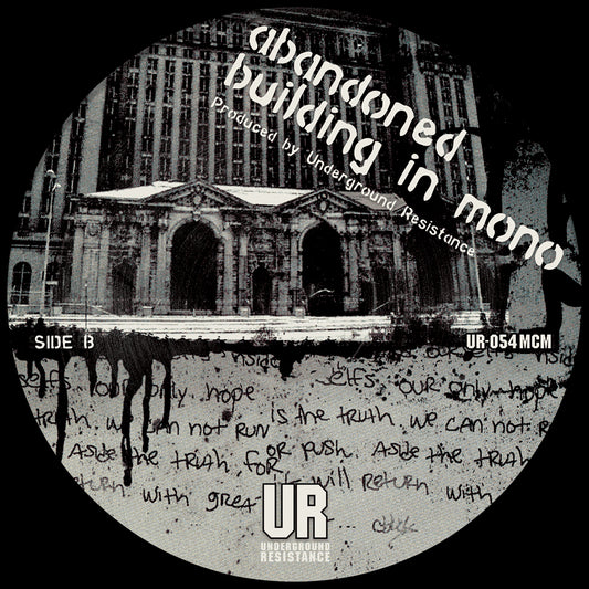 Lado B del vinilo Underground Resistance – Windchime 12" reedición, etiqueta en blanco y negro con edificio clásico, texto manuscrito, logo UR y referencia UR-054 MCM.