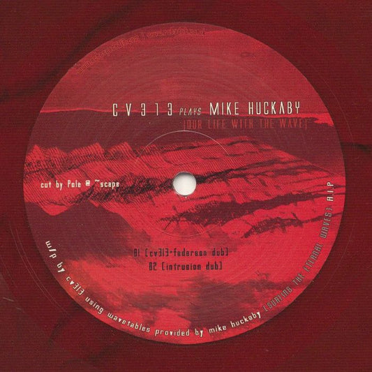 Etiqueta central lado B del vinilo cv313 Plays Mike Huckaby – Our Life With The Wave con diseño rojo jaspeado, incluye las pistas B1 cv313-Federsen Dub y B2 Intrusion Dub.