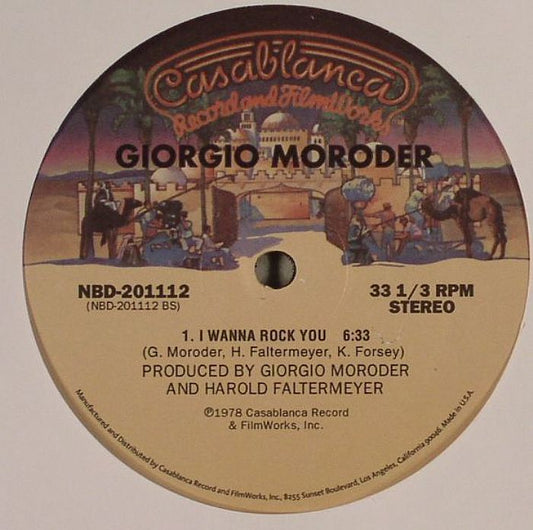 Etiqueta central del vinilo Giorgio Moroder – Evolution / I Wanna Rock You en el lado B, con la pista “I Wanna Rock You” (6:33) producida por Giorgio Moroder y Harold Faltermeyer; diseño clásico del sello Casablanca con tonos cálidos, catálogo NBD-201112, formato 12" reedición para coleccionistas.