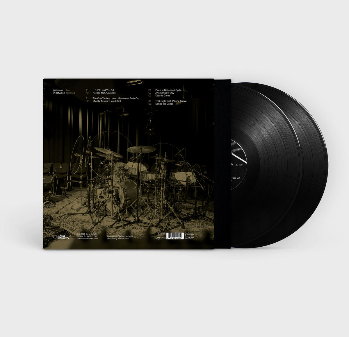 Contraportada del vinilo Jazzanova – In Between - Live Revisited abierta, con batería en estudio y vinilos visibles.