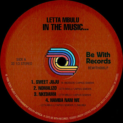 Etiqueta del lado A del vinilo Letta Mbulu – In The Music... The Village Never Ends de Be With Records. Texto impreso: lista de 4 temas, duración 33 1/3 RPM.