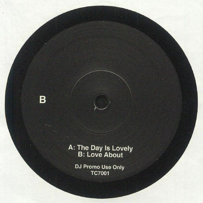 Etiqueta central lado B del vinilo LNTG – The Day Is Lovely / Love About en formato 7" promo, con pistas The Day Is Lovely y Love About, uso exclusivo DJ, catálogo TC7001.