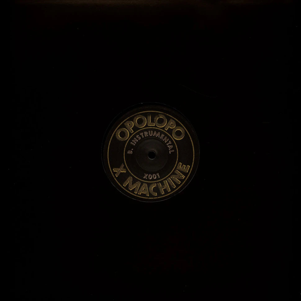 Funda negra del vinilo Opolopo – X Machine en 12" de Toolroom Records mostrando la etiqueta central con la cara B.