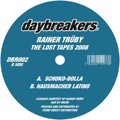 Etiqueta central del vinilo Rainer Trüby – The Lost Tapes 2008, lado B del sello Daybreakers 12", con créditos, catálogo DBR002 y pistas Schoko-Bolla y Hausmacher Latino en fondo azul.