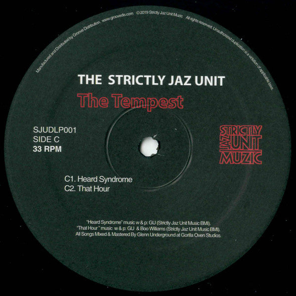 Centro del vinilo The Strictly Jaz Unit – The Tempest lado C, mostrando pistas “Heard Syndrome” y “That Hour”, catálogo SJUDLP001 y logo en rojo.