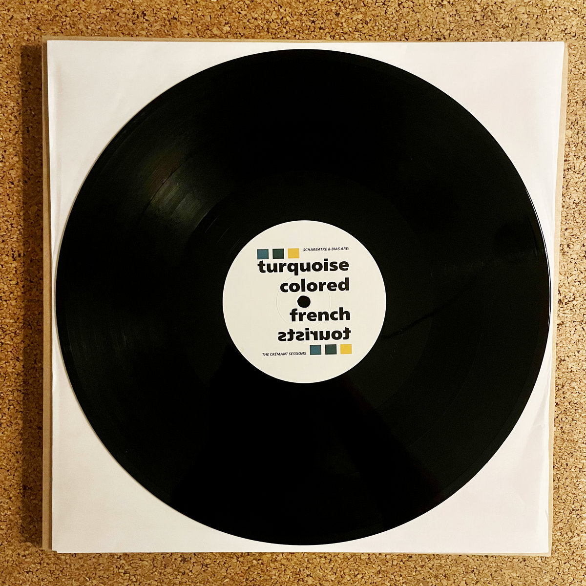 Portada del vinilo 12" EP Turquoise Colored French Tourists – The Cremant Sessions, disco negro sobre funda blanca con etiqueta gráfica central.