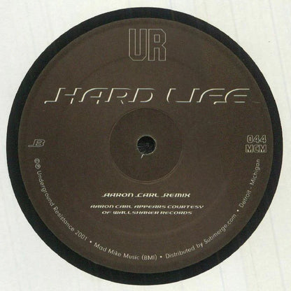 Lado B del vinilo UR – Hardlife, reedición 12" de Underground Resistance con Aaron Carl Remix destacado y catálogo 044 MCM en la etiqueta central.